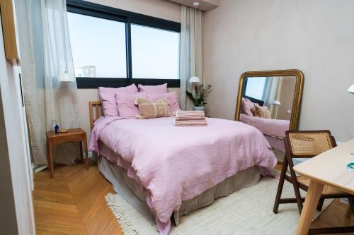a bedroom with a pink bed with a mirror at Penthouse Living in the Heart of Nicosia in Nicosia