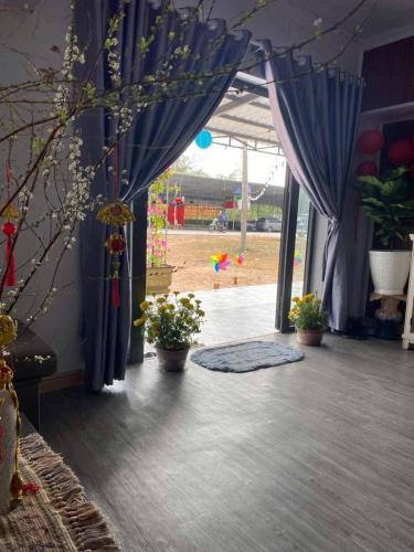 a room with blue curtains and potted plants on the floor at Ruby House beachside Ocean Hill in La Gi