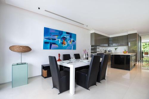 a dining room with a white table and black chairs at Private 3-Storey Pool Villa Atika 10, for 7, views of Patong Bay in Patong Beach