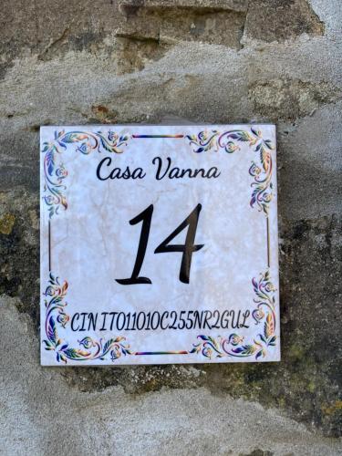 a sign on the side of a stone wall at Casa Vanna in Carrodano Superiore