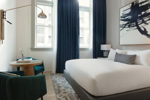 a hotel room with a bed and a chair at Kimpton - Pittman Hotel by IHG in Dallas