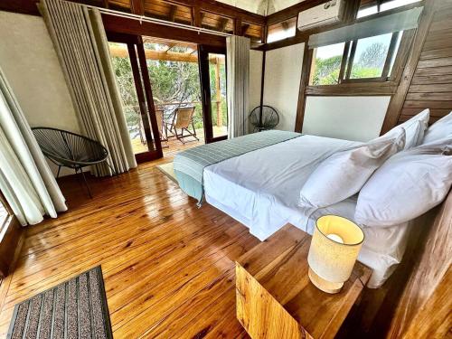 a bedroom with a bed and a wooden floor at Makana 7 in Ponta Mamoli
