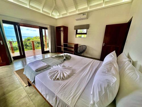 a bedroom with a large bed with white sheets and pillows at Makana 7 in Ponta Mamoli