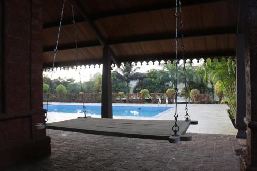 a swing in a pavilion with a swimming pool at The Redstone Oasis Villa in Welhe