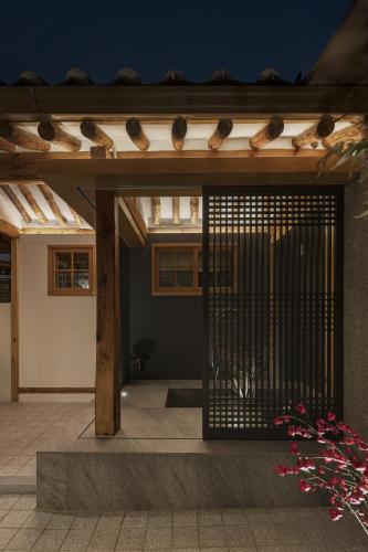 a gate to a house with birds on the roof at Nostalgia Hanok Hotel in Seoul