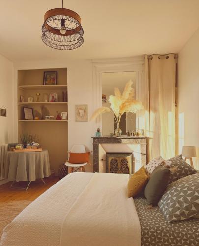 a bedroom with a large bed and a fireplace at MAISON 54 in Bernay