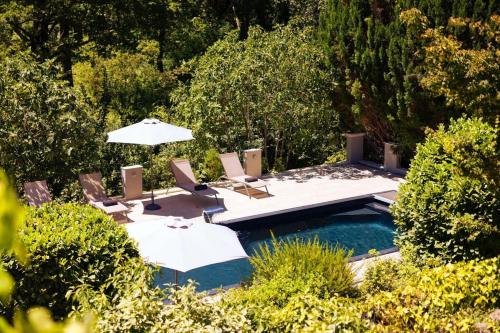 une piscine avec parasols et chaises et une piscine dans l'établissement Charming Villa in the South of France with Private Pool and Gardens, à Tourrettes