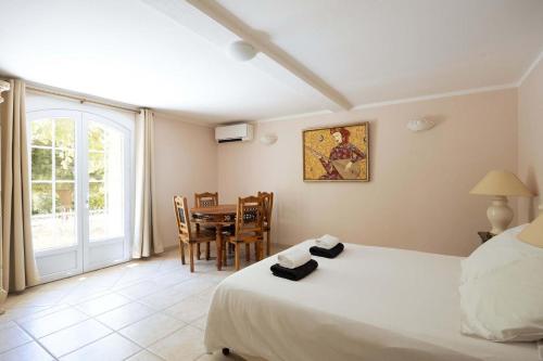une chambre avec un lit, une table et des chaises dans l'établissement Charming Villa in the South of France with Private Pool and Gardens, à Tourrettes