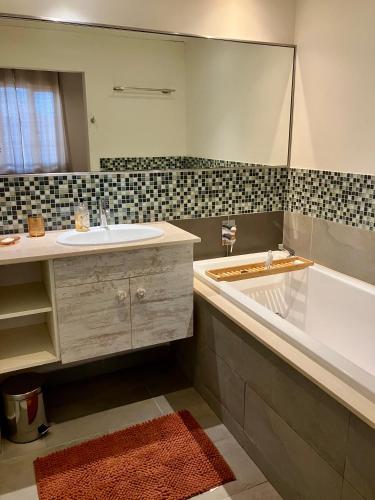 a bathroom with a sink and a tub and a mirror at sea beach pool in Bain Boeuf