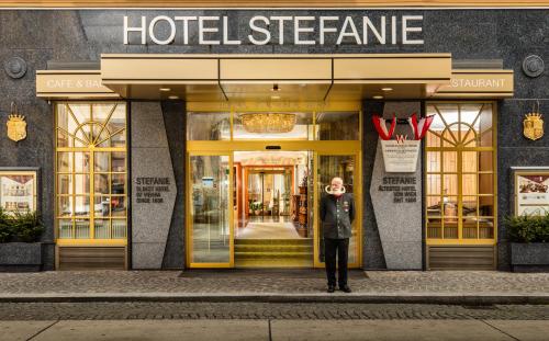 un homme debout devant un magasin d'hôtel dans l'établissement Hotel Stefanie - VIENNA'S OLDEST HOTEL, à Vienne