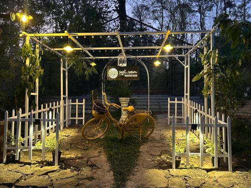 a yellow bike parked under a shed with lights at SylVan Resort in Wayanad