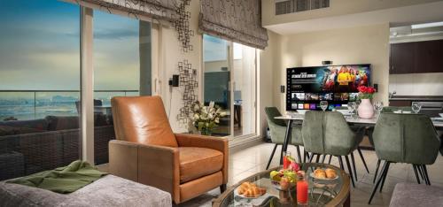 a living room with a table and a dining room at Reem Island Beach Haven with Stellar Balcony Views in Abu Dhabi