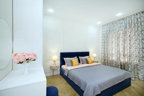 a bedroom with a bed and a vase of flowers at Central Light Apartment in Almaty