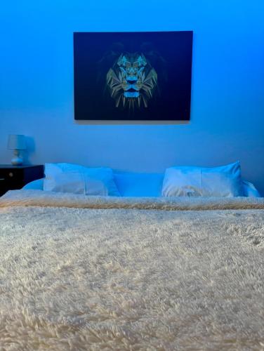 a blue room with a bed with a painting on the wall at UltraCentral Cozy Apartment in Oradea