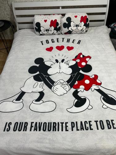 a bed with a hello kitty comforter on it at Vieno kambario apartamentai Telšiuose in Telšiai