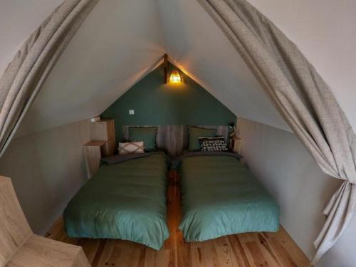 a room with two green beds in a attic at L'ecrin de lacoste in Chasteaux