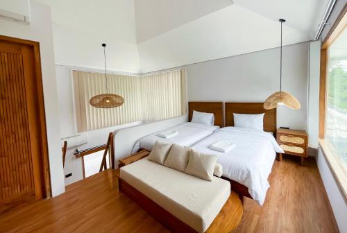 a bedroom with a large bed and a chair at Marades Limasan Villa Yogyakarta in Yogyakarta