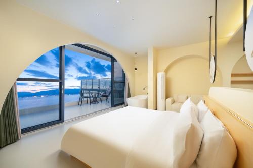 a bedroom with a white bed and a large window at 大理麓屿悬崖海景民宿 in Dali