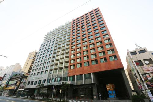 a tall building on a city street at Hotel Air City Jeju in Jeju