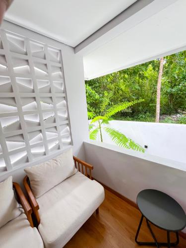 a living room with a white couch and a window at Marades Limasan Villa Yogyakarta in Yogyakarta