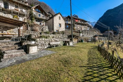 a village in the mountains with buildings and grass at Rustico Over The Bridge Verzasca in Lavertezzo