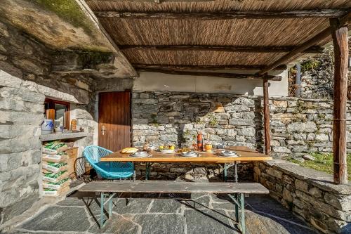 a wooden table and chairs in a stone building at Rustico Over The Bridge Verzasca in Lavertezzo