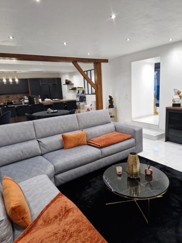 a living room with a gray couch and a table at Infinity marbre in Cérans-Foulletourte