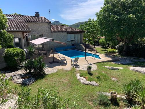 une maison avec une piscine dans une cour dans l'établissement La Peireta-Romantique, à Saint Alban Auriolles
