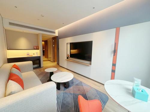 a living room with a couch and a tv at Holiday Inn Express Hangzhou Jiangnan by IHG in Hangzhou
