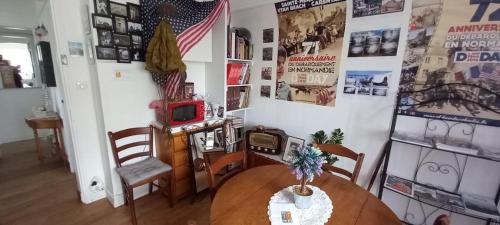 une chambre avec une table et une chambre avec des affiches sur le mur dans l'établissement Les villégiatures de Muse, à Saint-Marcouf