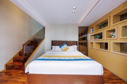 a bedroom with a large bed and a staircase at Argyle WAIFIDEN Baolidian Hotel -Free shuttle bus during Canton Fair in Guangzhou