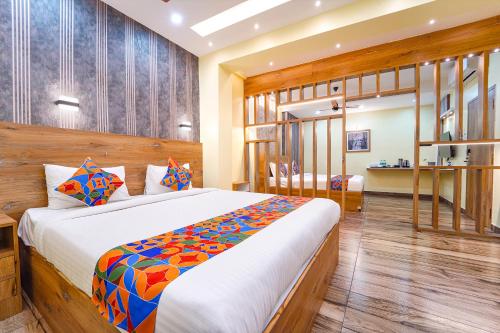 Un dormitorio con una cama grande en una habitación. en FabHotel INK - Nr Coimbatore North Railway Station, en Coimbatore