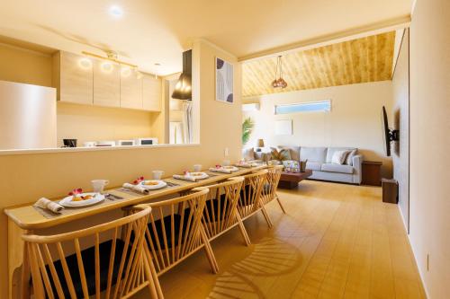 a kitchen and living room with a table and chairs at YANBARU Villa 葵扇-KISEN- in Motobu