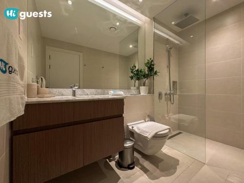 a bathroom with a toilet and a sink and a shower at HiGuest - Stylish 1BR Apartment in La Mer in Dubai