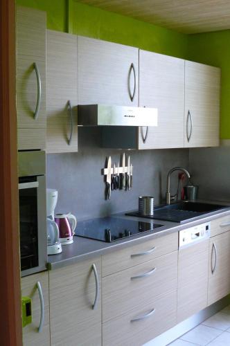 une cuisine avec des armoires en bois et un évier dans l'établissement Grand meublé 70 m2 centre-ville proche lac, à Annecy