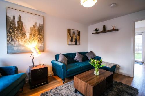 a living room with a blue couch and a table at Lux 3 Bed Home in Somerset with 2 Parking Spaces & Wifi in Wells