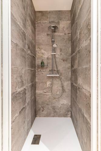 La salle de bains est pourvue d'une douche et d'un mur en pierre. dans l'établissement Le Pressoir du Château de Framboise, à Dumes