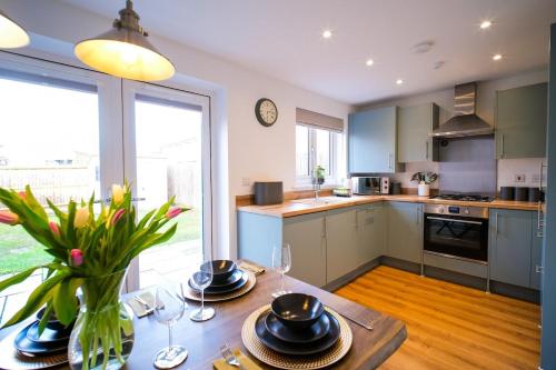 a kitchen with a table with plates and glasses on it at Lux 3 Bed Home in Somerset with 2 Parking Spaces & Wifi in Wells