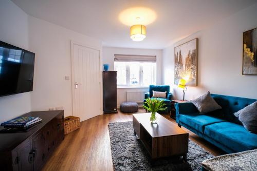 a living room with a blue couch and a table at Lux 3 Bed Home in Somerset with 2 Parking Spaces & Wifi in Wells