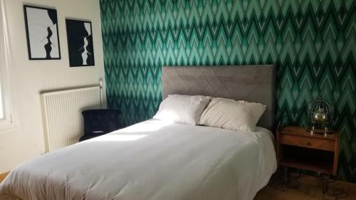 une chambre avec un lit et un mur végétal dans l'établissement Maison familiale Amboise, à Amboise