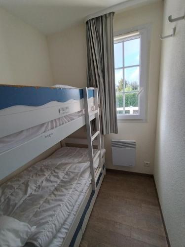 une petite chambre avec deux lits superposés et une fenêtre dans l'établissement A11 - appartement vue mer avec piscine, à Fouesnant