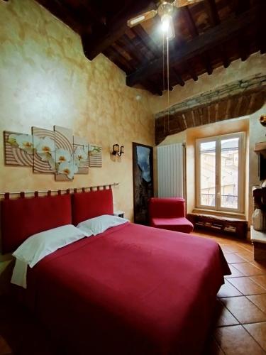 a bedroom with a red bed and a red chair at Antica Tibur in Tivoli