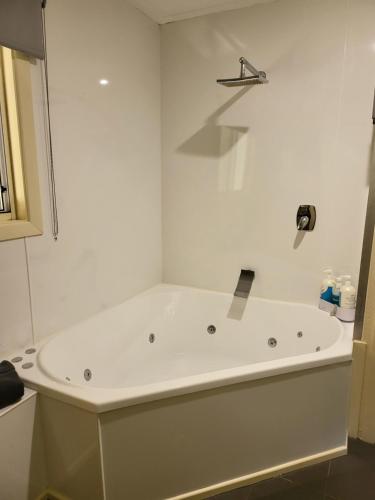 a white tub in a bathroom with a shower at Chilverton Cottages in Ravenshoe