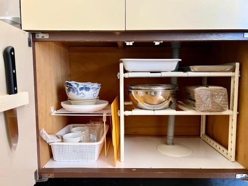 a cupboard with dishes and other kitchen utensils at サンライズ in Nagano