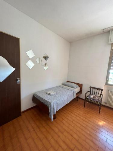 a small bedroom with a bed and a chair at Friuli in Cormòns