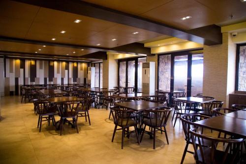 a dining room with tables and chairs and windows at Splendido Tagaytay Hotel and Country Club in Tagaytay