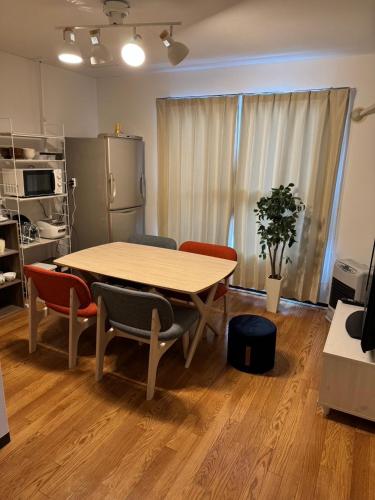 a table and chairs in a room with a kitchen at STAY Moiwayama in Sapporo