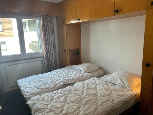 an unmade bed in a bedroom with a window at Diablerets D 010 -MOUNTAIN apartment 6 pers in Veysonnaz