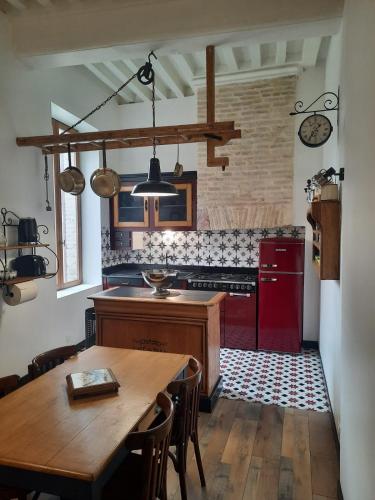 Il comprend une cuisine équipée d'une table en bois et d'une cuisinière rouge. dans l'établissement La belle époque, à Verdun-sur-le-Doubs