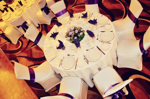 a white table with white chairs and a table with flowers at Holiday Inn & Suites Parsippany Fairfield by IHG in Parsippany